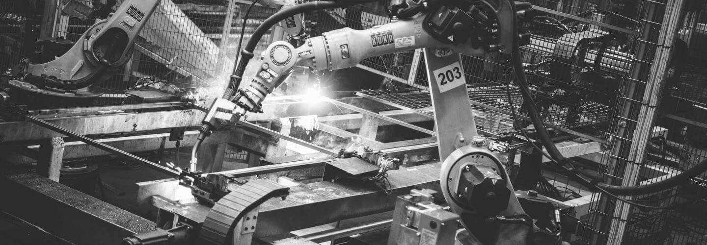 Robots welding shielded by a Troax machine guarding.
