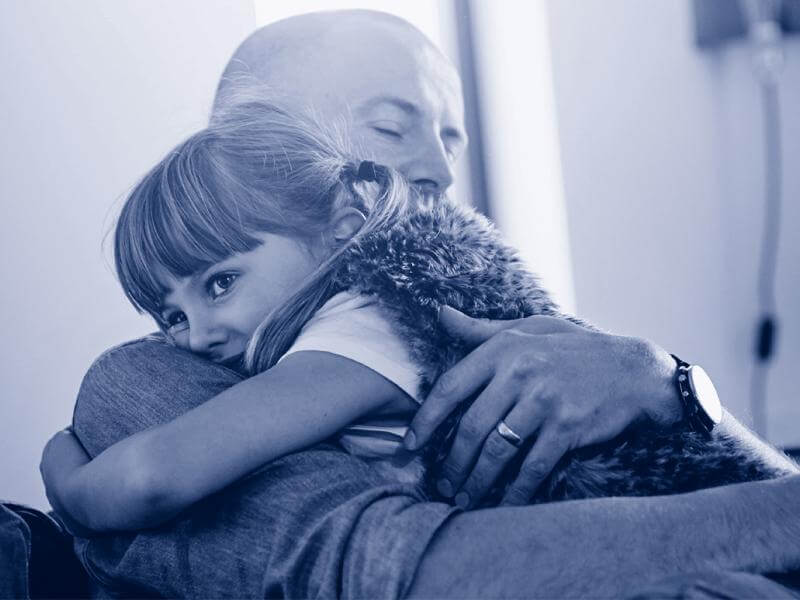 Dad and daughter hugging each other.
